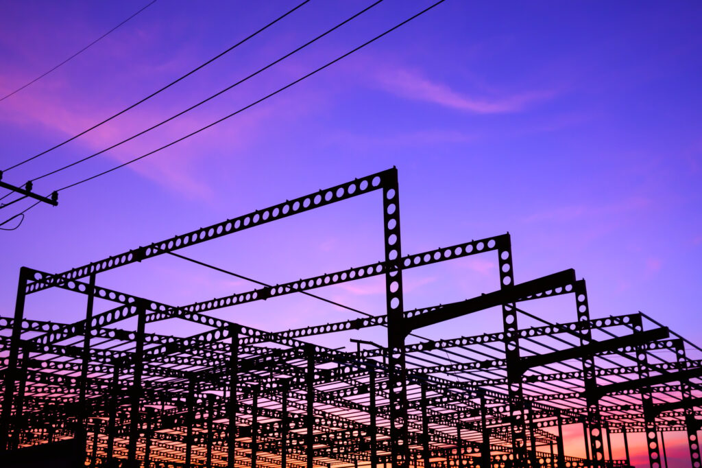 Silhouette of metal castellated beam of large industrial building structure against twilight sky